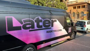 Gros plan sur le flanc d'un van Mercedes Sprinter VIP floqué au logo rose LATER et QR code, mobilisé par EDEN CAB, entreprise de chauffeur privé.