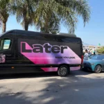Van Mercedes Sprinter VIP noir personnalisé au logo rose LATER sous les palmiers aux Cannes Lions, avec les services d'EDEN CAB, entreprise de chauffeur privé.