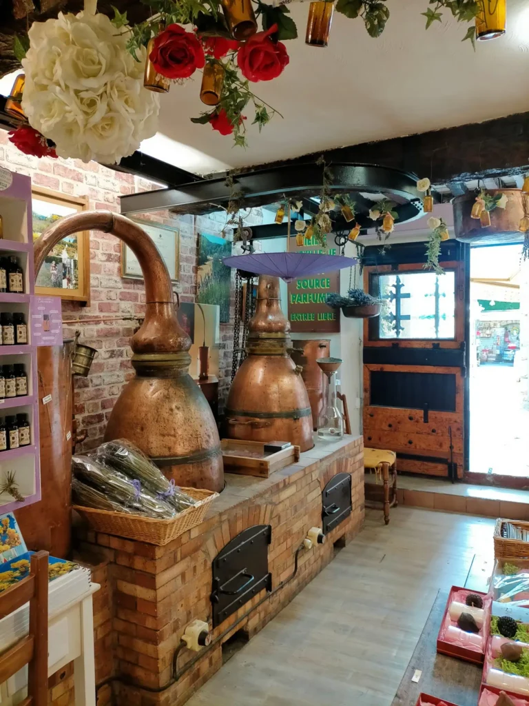 La boutique La Source Parfumée à Gourdon, présentant des bougies artisanales et des flacons de parfums locaux.