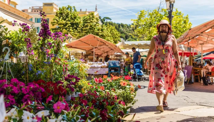 Marché aux fleurs du Cours Saleya à Nice avec ses stores à rayures colorées et ses étals fleuris sous le soleil.