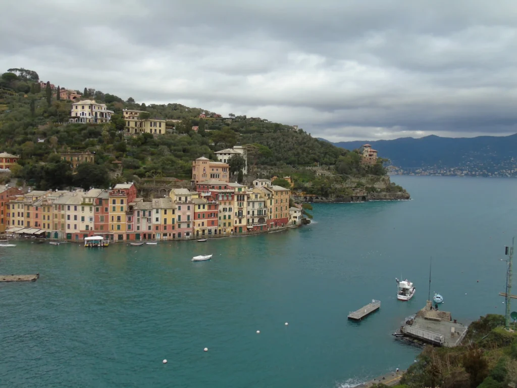 Vue panoramique en hauteur sur le port de Portofino, ses maisons colorées liguriennes et la mer turquoise.