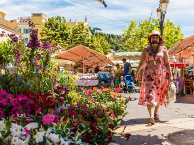 Marché aux fleurs du Cours Saleya à Nice avec ses stores à rayures colorées et ses étals fleuris sous le soleil.