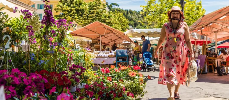 Marché aux fleurs du Cours Saleya à Nice avec ses stores à rayures colorées et ses étals fleuris sous le soleil.
