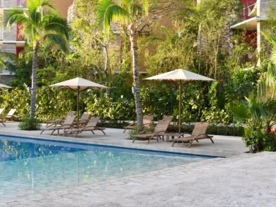Piscine extérieure et transats ombragés sous les palmiers comme dans un hotel saint tropez luxe d'exception.