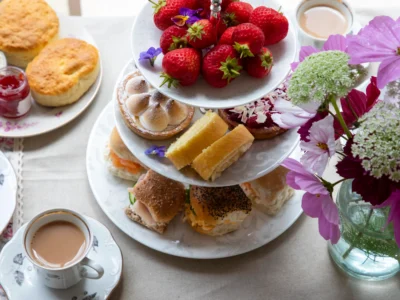 Présentoir à étages garni de fraises fraîches, pâtisseries, scones et petits sandwichs pour savoir où prendre le thé sur la Côte d'Azur.
