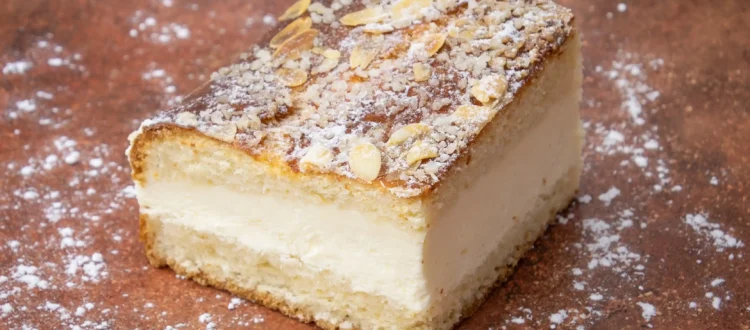 Part de tarte tropézienne avec crème onctueuse, amandes effilées et sucre grain, emblème des spécialités de Saint-Tropez.