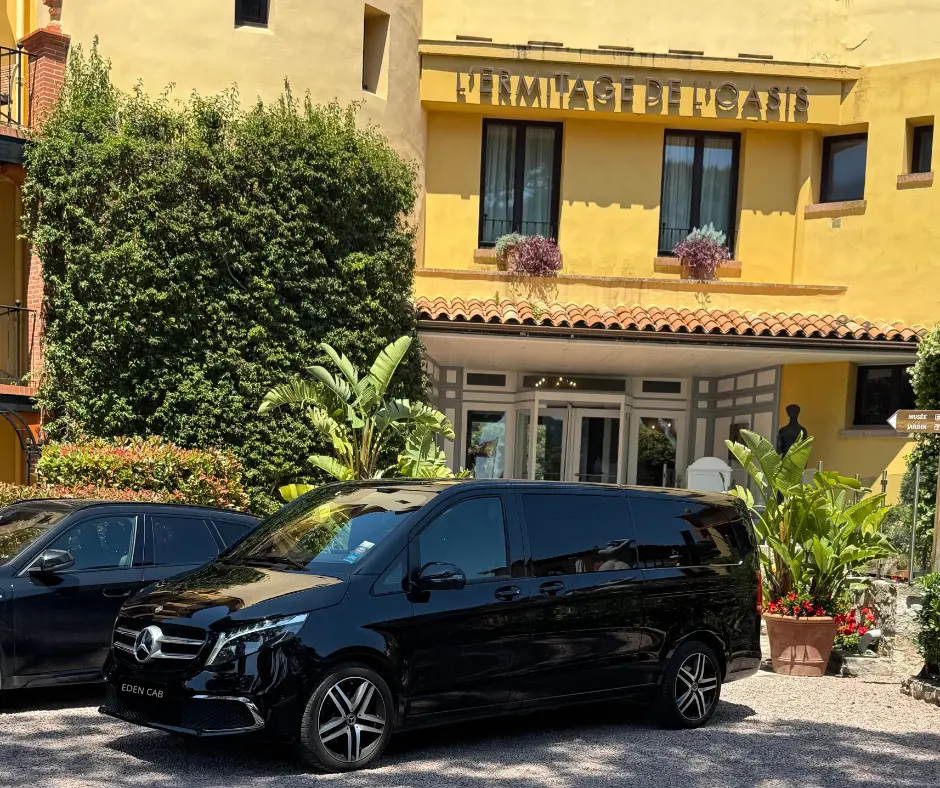 Van Mercedes noir Eden Cab stationné devant l'hôtel L'Ermitage de l'Oasis, illustrant le meilleur VTC de la Côte d'Azur.