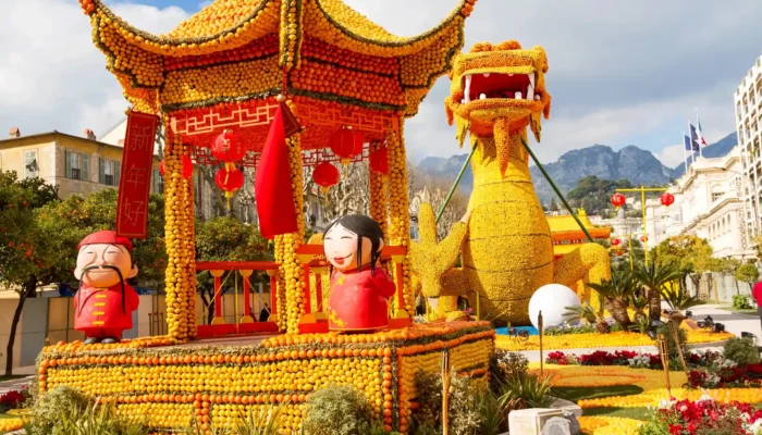 Sculpture monumentale d'un dragon impérial et d'un temple chinois réalisés en citrons et oranges à la Fête du Citron de Menton.