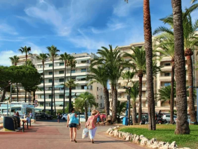 Promenade de la Croisette à Cannes, bordée de palmiers, plages et hôtels de luxe.
