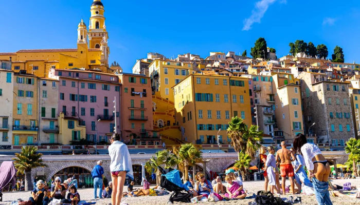 Vue pittoresque de la ville de Menton sur la Côte d'Azur, ses maisons colorées s'étendant du littoral méditerranéen aux collines, sous un ciel bleu
