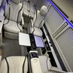 Intérieur du Mercedes sprinter vip avec les 4 sièges avant disposés face à face et les 3 sièges arrière allongés comme un lit