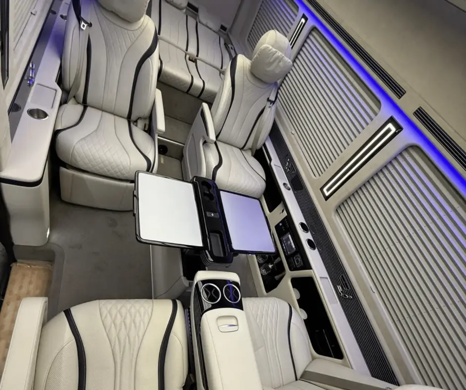 Intérieur du Mercedes sprinter vip avec les 4 sièges avant disposés face à face et les 3 sièges arrière allongés comme un lit