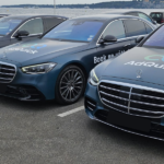 Alignement de quatre berlines de luxe Mercedes Classe S bleu nuit floquées du logo AD QUICK sur un parking en bord de mer, illustrant un service de chauffeur privé pour entreprise haut de gamme.