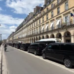 Cortège de vans Mercedes Classe V noirs EDEN CAB stationnés en file indienne le long de la rue de Rivoli à Paris pour une mission diplomatique.