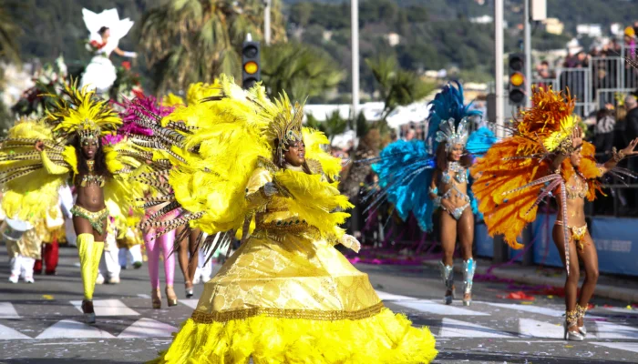 Carnaval de Nice, évènement Côte d’Azur incontournable avec danseuses et ambiance festive.
