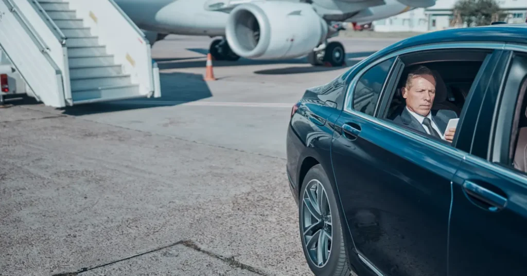 VIP client escorted onto the tarmac in a limousine service vehicle by a private chauffeur
