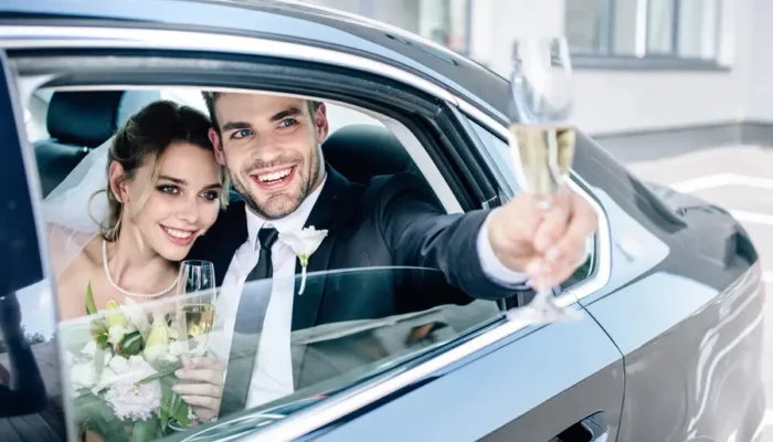 Couple de mariés élégants assis dans une limousine lors de leur mariage