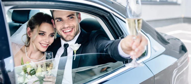 Couple de mariés élégants assis dans une limousine lors de leur mariage