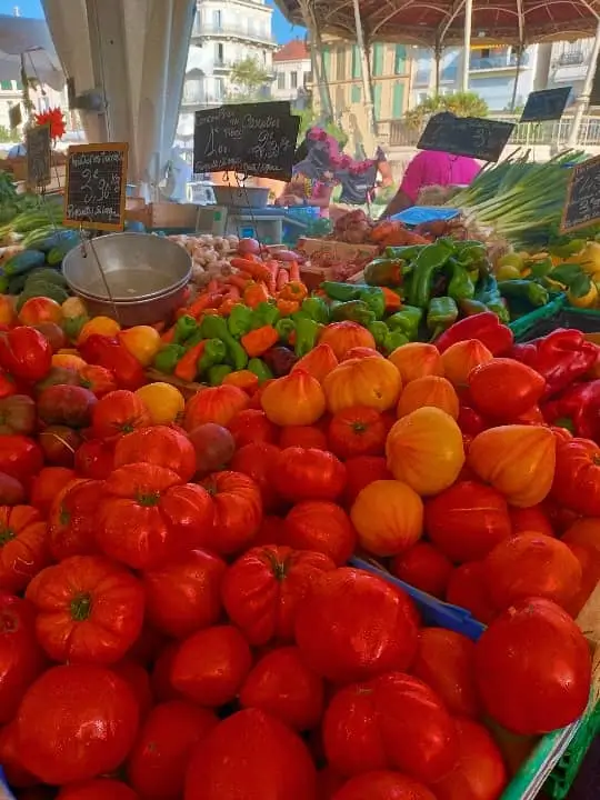 Étaux de maraîchers locaux remplis de légumes de saison dans l'allée centrale du marché couvert Forville à Cannes.@jeanpaul 2025