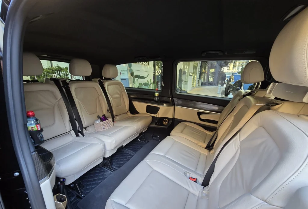 Interieur de la Mercedes V class avec ses sièges en cuir blanc disposés face à face, pour une location de van Mercedes Classe V.